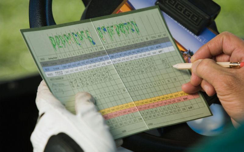 A golfer examines their scorecard after a challenging round