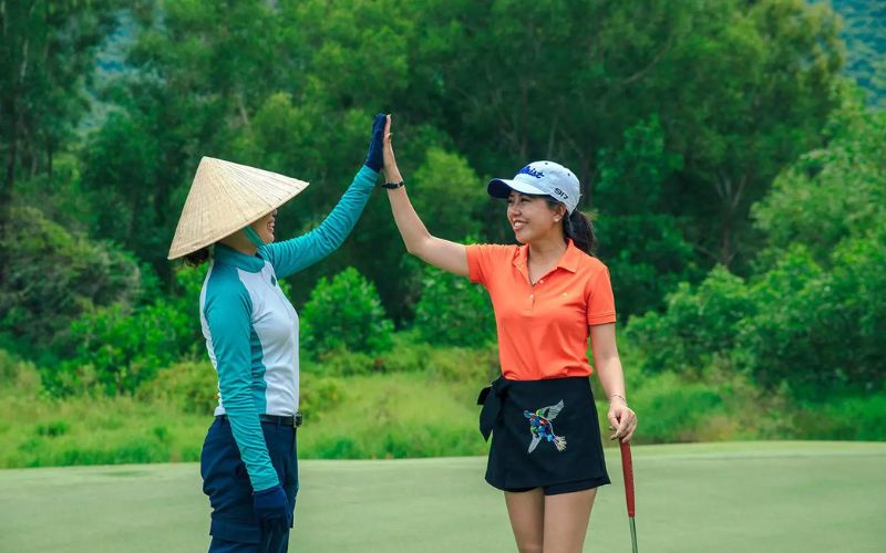 A golfer cheers up with her caddie