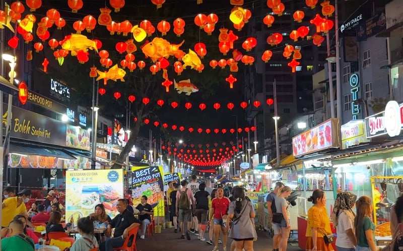 Jalan Alor comes alive at night with colorful lights and bustling food stalls