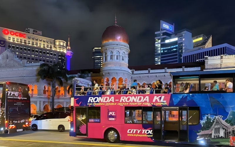 Tourists enjoying the panoramic view from the upper deck of the KL bus