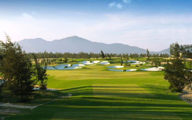 Scenic golf course at Phoenix Golf Resort, featuring green fairways framed by tall limestone mountains and dense greenery