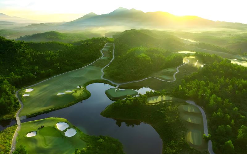 Ba Na Hills Golf Club at sunrise with misty hills, reflective lakes, and lush green fairways.