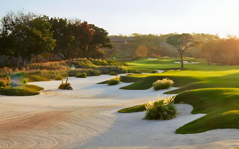 Bali National Golf Club at sunset with lush fairways and sand bunkers.