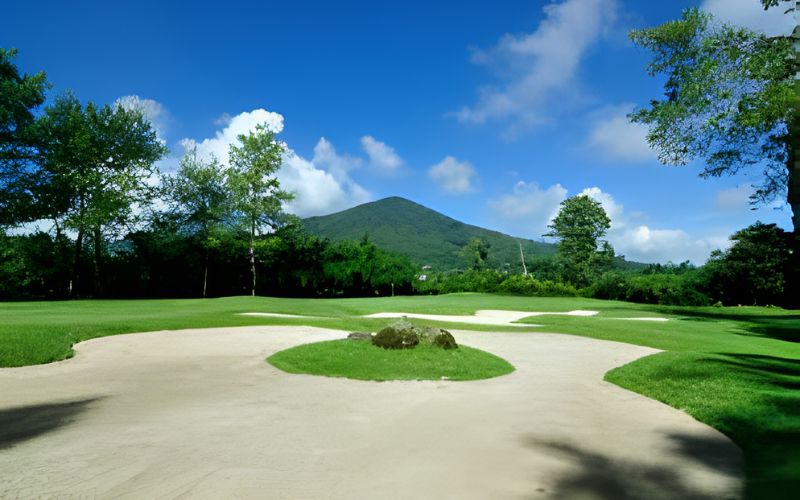 Handara Golf Resort Bali surrounded by lush greenery, mountain backdrop, and bright blue sky in Bedugul, Indonesia.