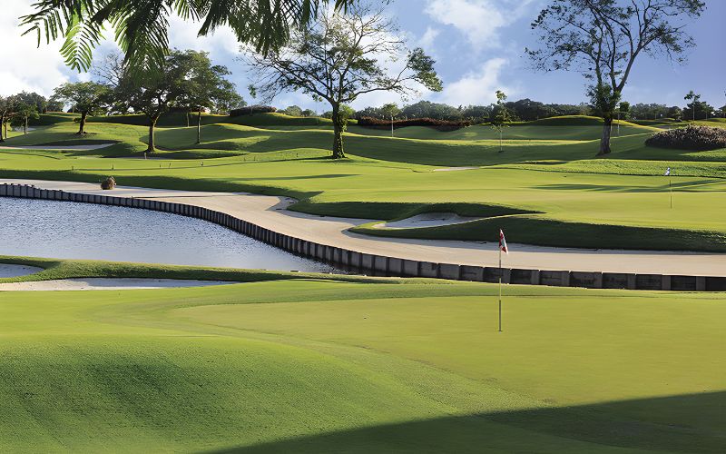 View of Laguna National Golf Resort in Singapore featuring manicured greens, water hazards, and trees under a bright sky