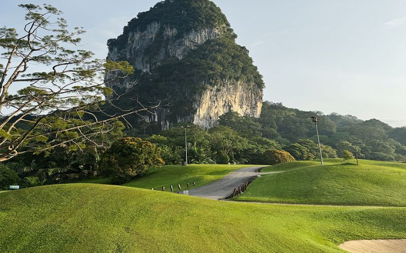 Beautiful view of Templer Park Country Club golf course with lush green fairways, surrounding trees, and a towering limestone hill in the background.
