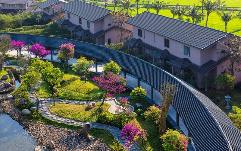 Aerial view of Kobi Onsen Hue, showing elegant villas surrounded by landscaped gardens, colorful flowers