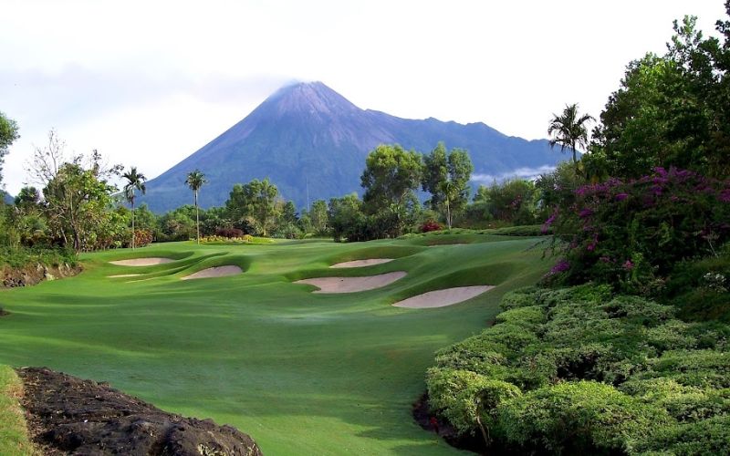 Beautiful view of Merapi Golf Course in Yogyakarta with Mount Merapi in the background, surrounded by lush greenery and tropical landscape.