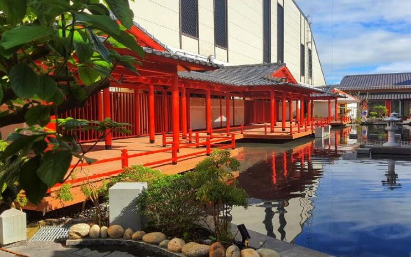 Red Japanese-style walkways beside a reflective pond at Mikazuki Japanese Resort & Spa Danang.