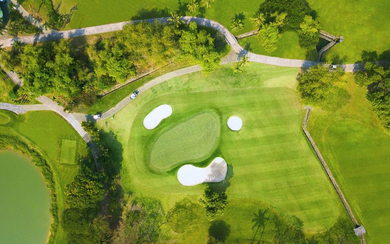 An aerial view of the Song Be Golf Resort green, showing multiple white sand bunkers surrounding the putting surface.