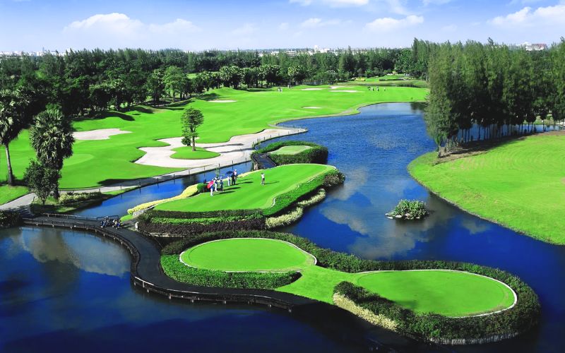 Aerial view of Summit Windmill Golf Club in Bangkok featuring green fairways, island-style greens, and surrounding water hazards.