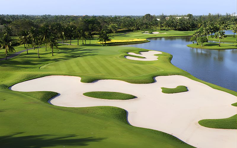 Aerial view of Thai Country Club golf course in Bangkok featuring lush fairways, large sand bunkers, and a scenic water hazard.