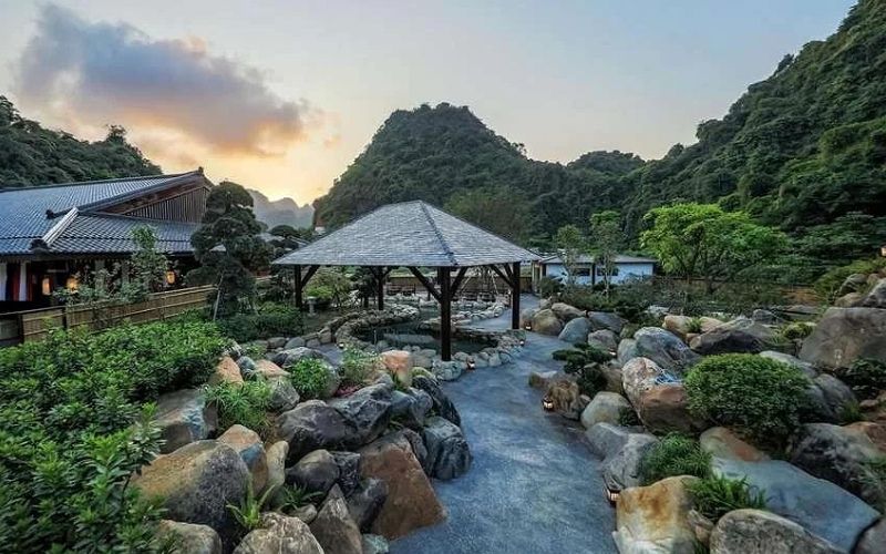 Yoko Onsen Quang Hanh in northern Vietnam, surrounded by lush green mountains, natural stone paths, and traditional hot spring baths