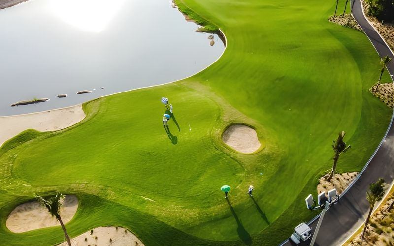 Aerial view of a bright green fairway at BRG Da Nang Golf Club with bunkers and surrounding pathways