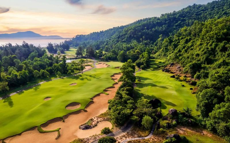 Laguna Lang Co Golf Club Vietnam featuring rolling fairways, strategically placed bunkers, lush tropical mountains, and panoramic valley views.