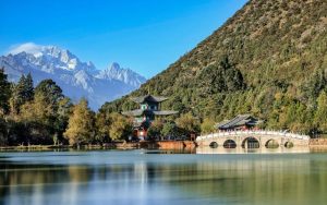 Black Dragon Pool in Lijiang with an arched bridge and Jade Dragon Snow Mountain in the background