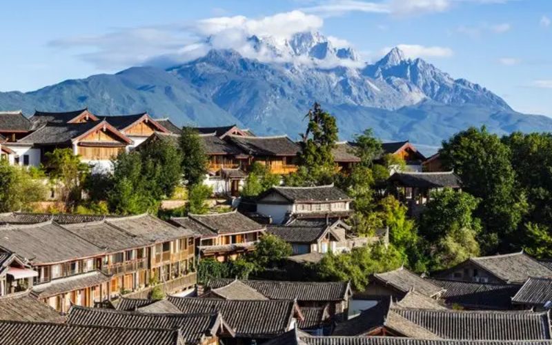 Traditional rooftops of Lijiang Old Town overlooking Jade Dragon Snow Mountain in Yunnan, China
