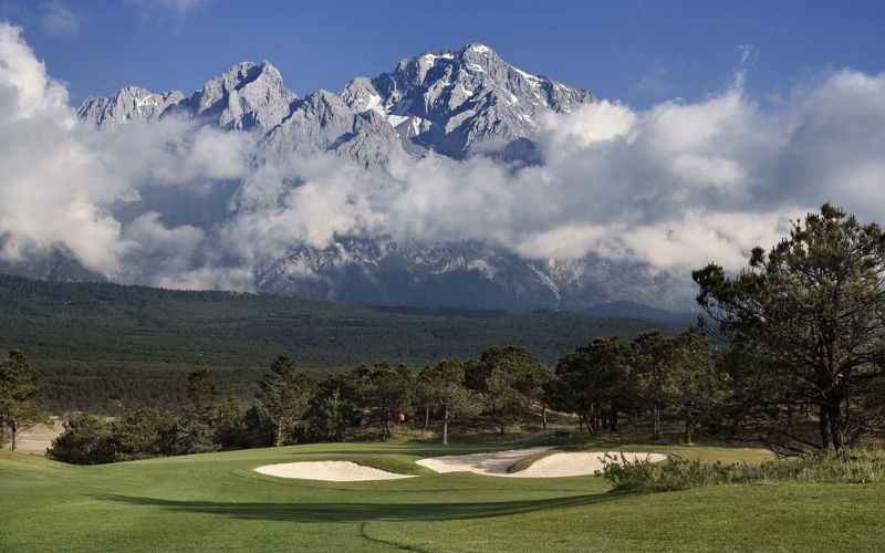 Jade Dragon Snow Mountain Golf Club fairway with mountain backdrop in Lijiang, Yunnan